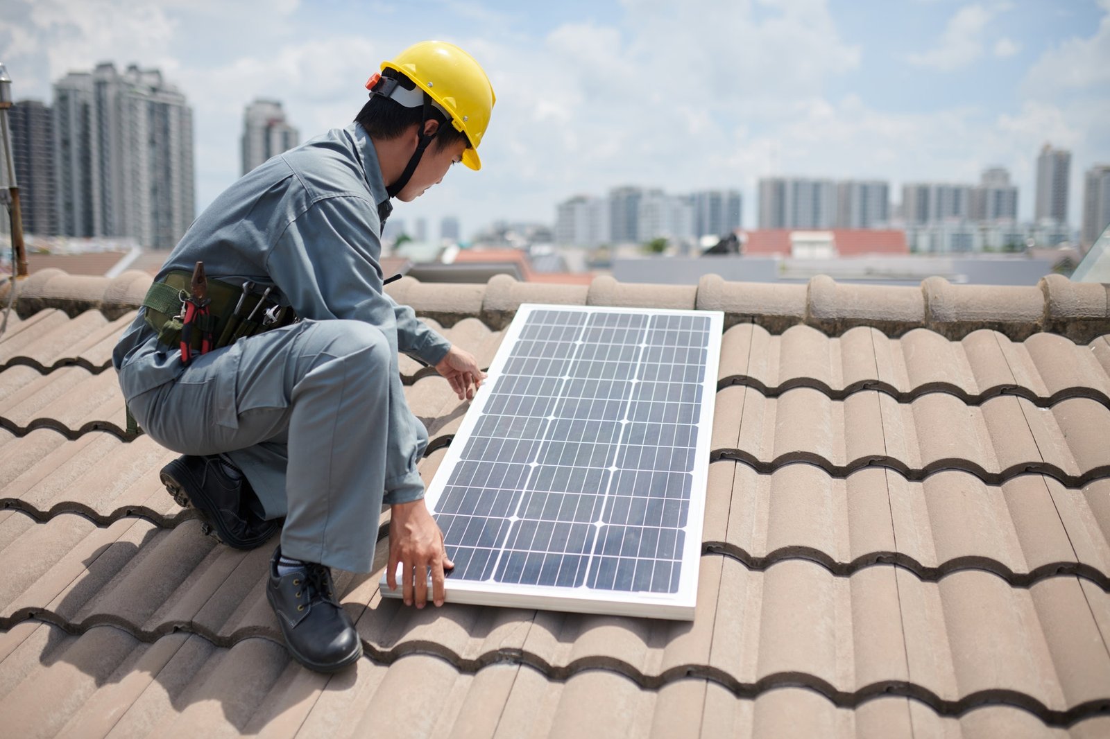 Worker Installing Solar Panels on Roof